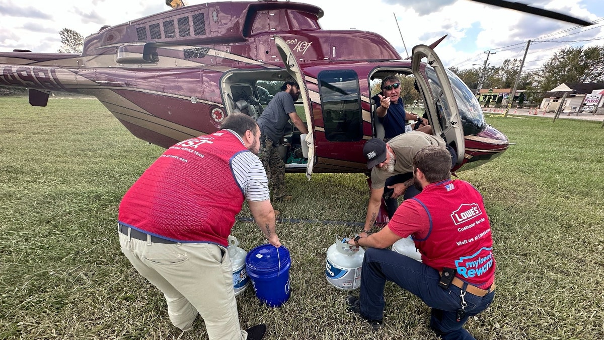 Hadley and other volunteers collect supplies in Hadley's helicopter