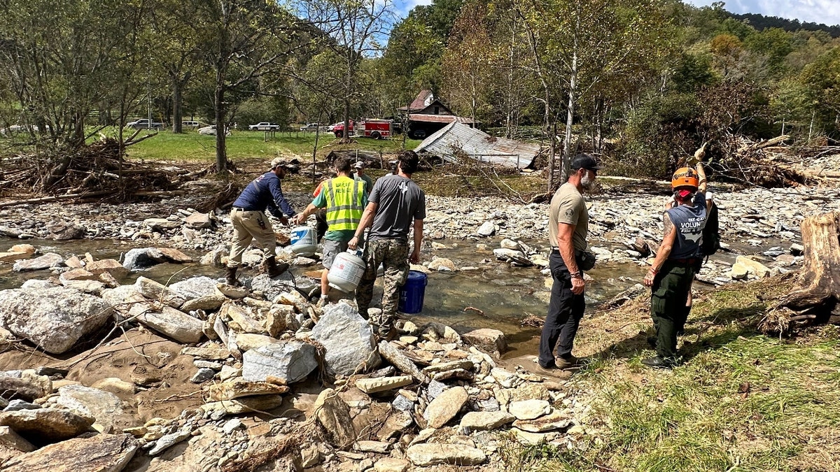 Volunteers transverse  a creek to present  supplies successful  North Carolina aft  Hurricane Helene