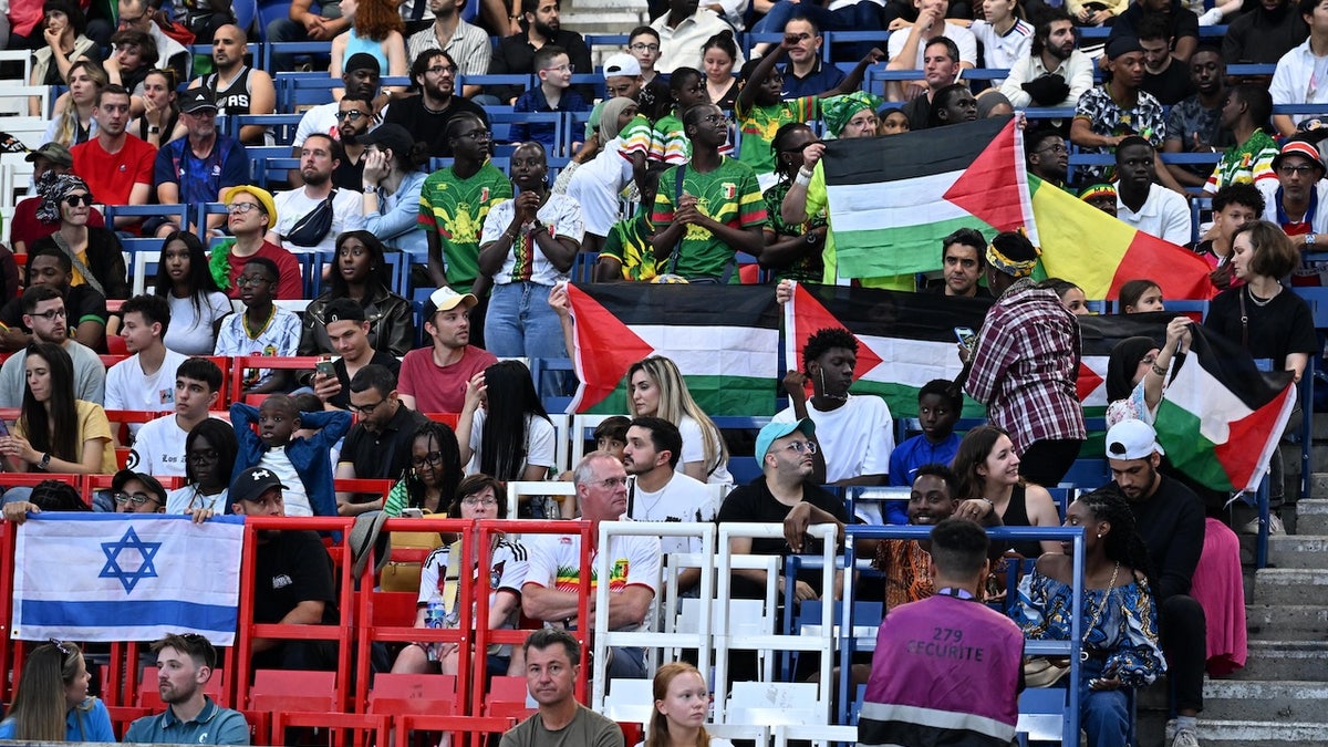 Aficionados abren banderas palestinas durante el partido del grupo D masculino entre Mali e Israel durante los Juegos Olímpicos de París 2024 en el estadio Parc des Princes de París, Francia, el 24 de julio de 2024. 