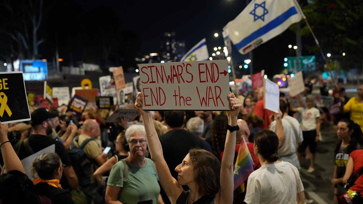 An Israeli holds a sign about the death of a Hamas leader in Gaza