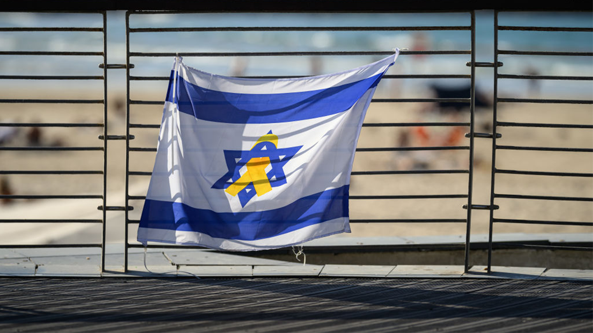 Una bandera de Israel con un lazo amarillo