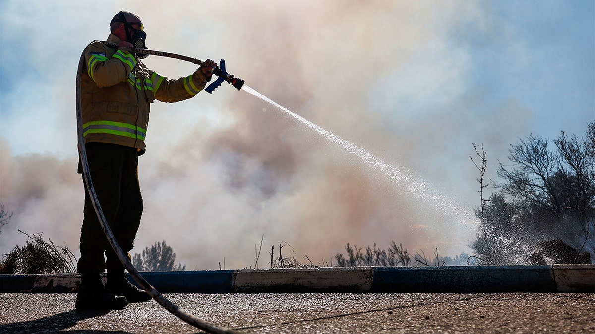 Equipe de resgate de bombeiros responde ao local de um ataque de foguete