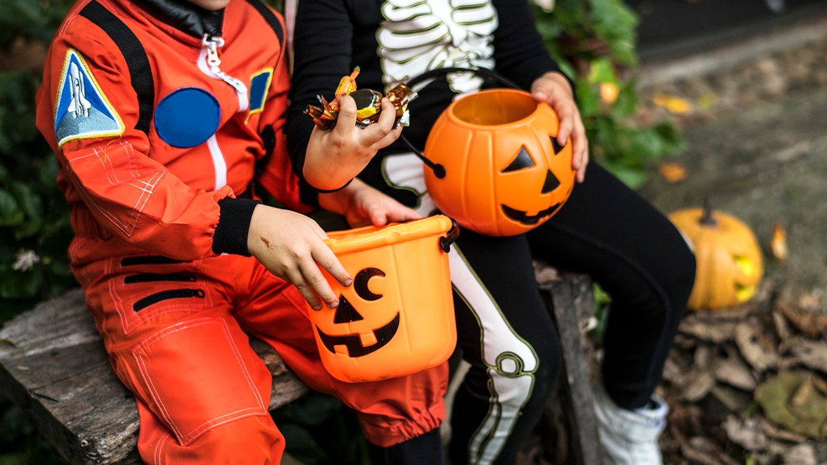 Niños pequeños piden dulces en Halloween