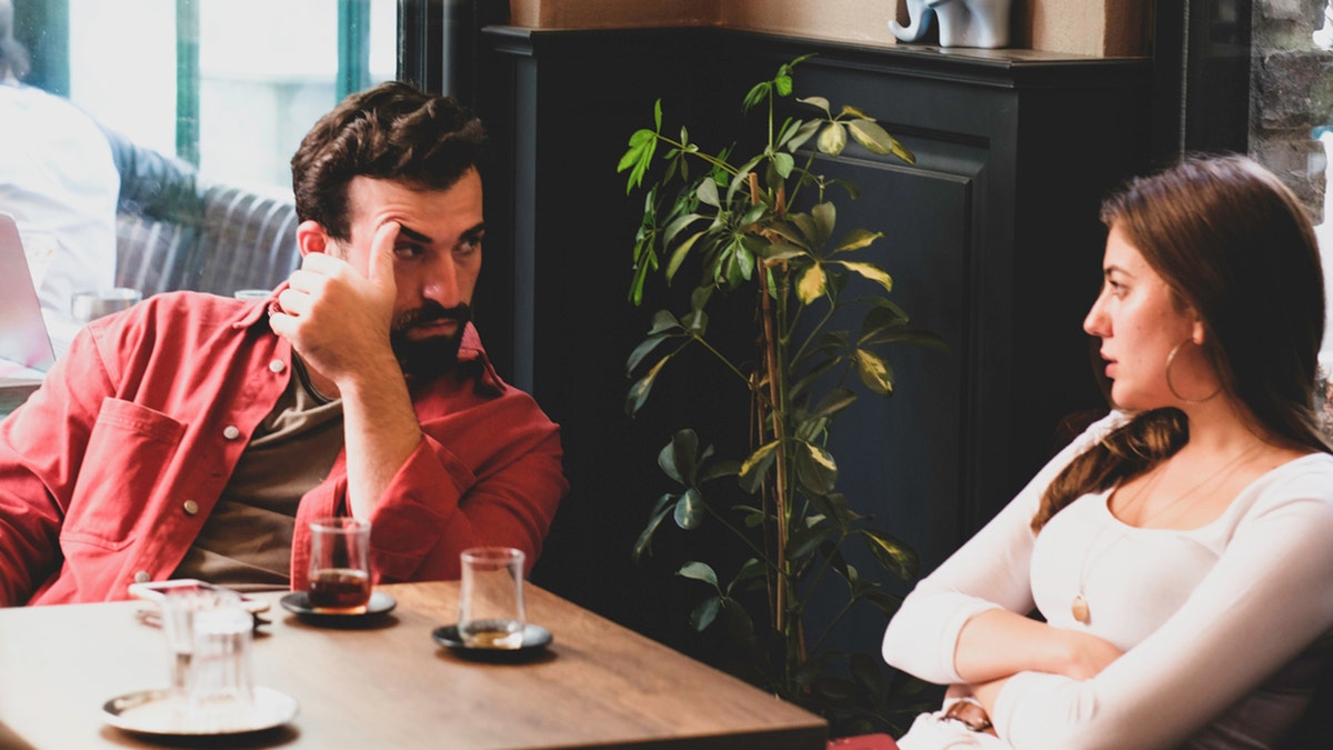 Pareja discutiendo en un café