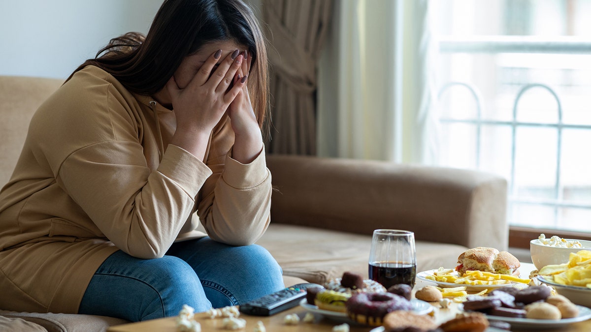 mujer estresada con comida en la mesa