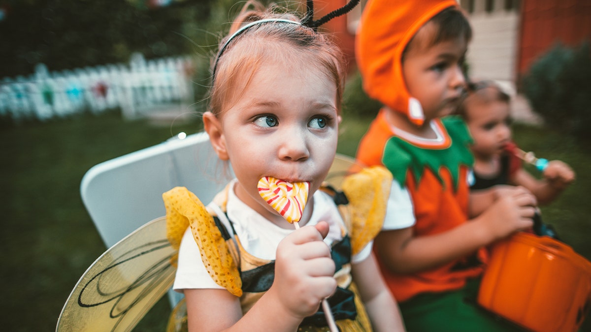 Niña comiendo caramelos en Halloween