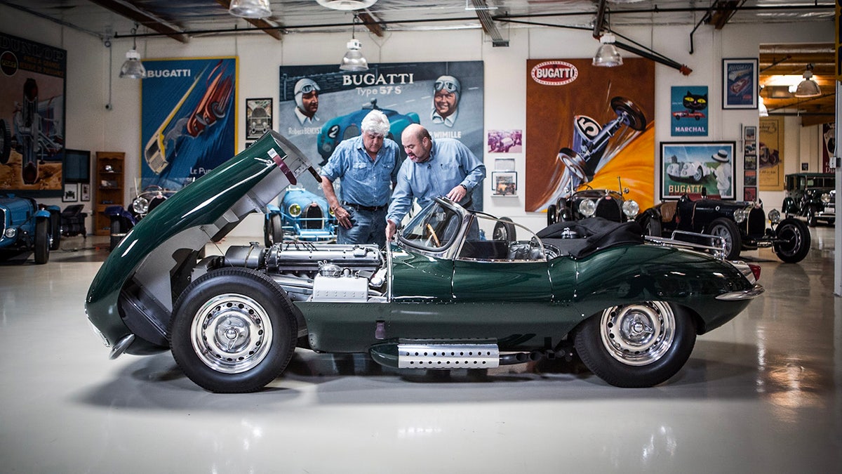 Jay Leno looks at a car with another person