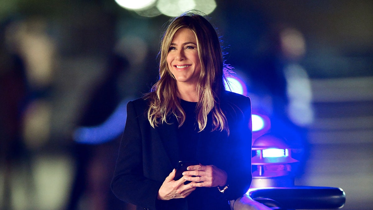 Jennifer Aniston smiling standing on the street