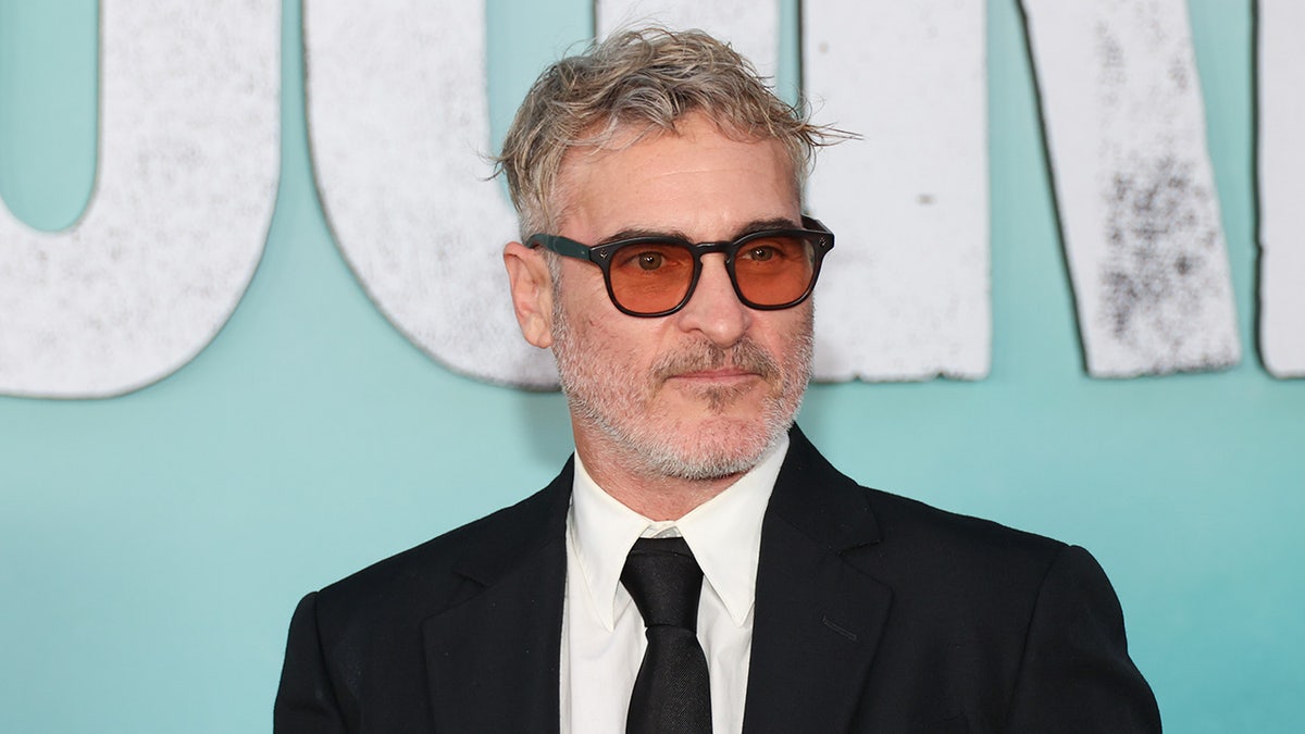 Close-up of Joaquin Phoenix wearing sunglasses on the red carpet