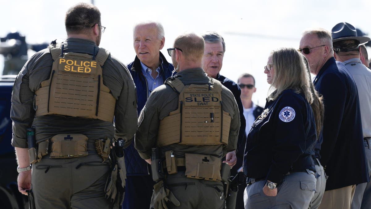 El presidente Biden y el gobernador de Carolina del Norte, Roy Cooper, saludan a los socorristas tras recorrer el miércoles las zonas afectadas por el huracán Helene.