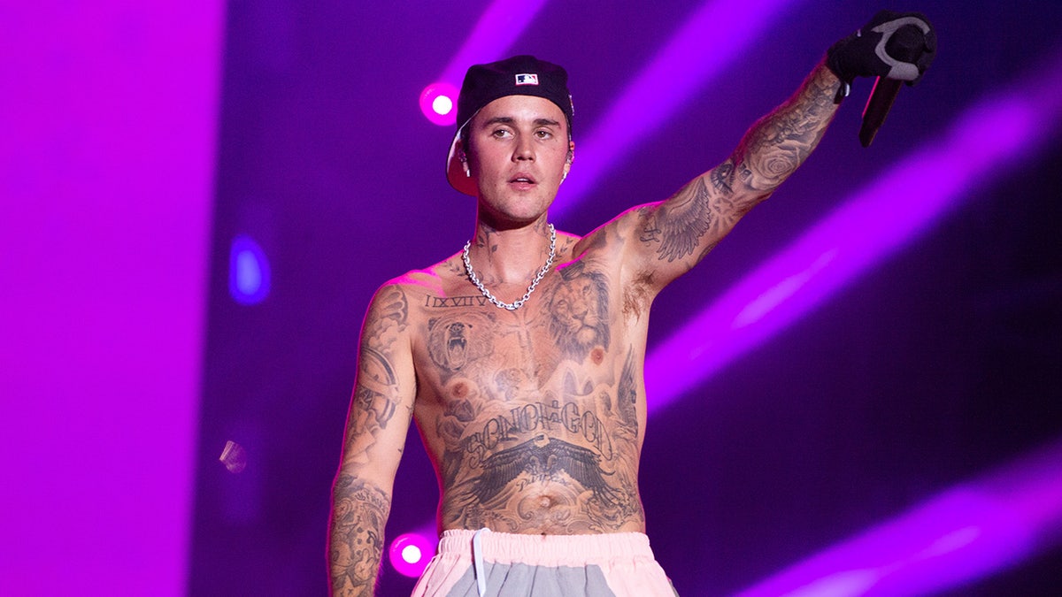 Justin Bieber stands shirtless on stage