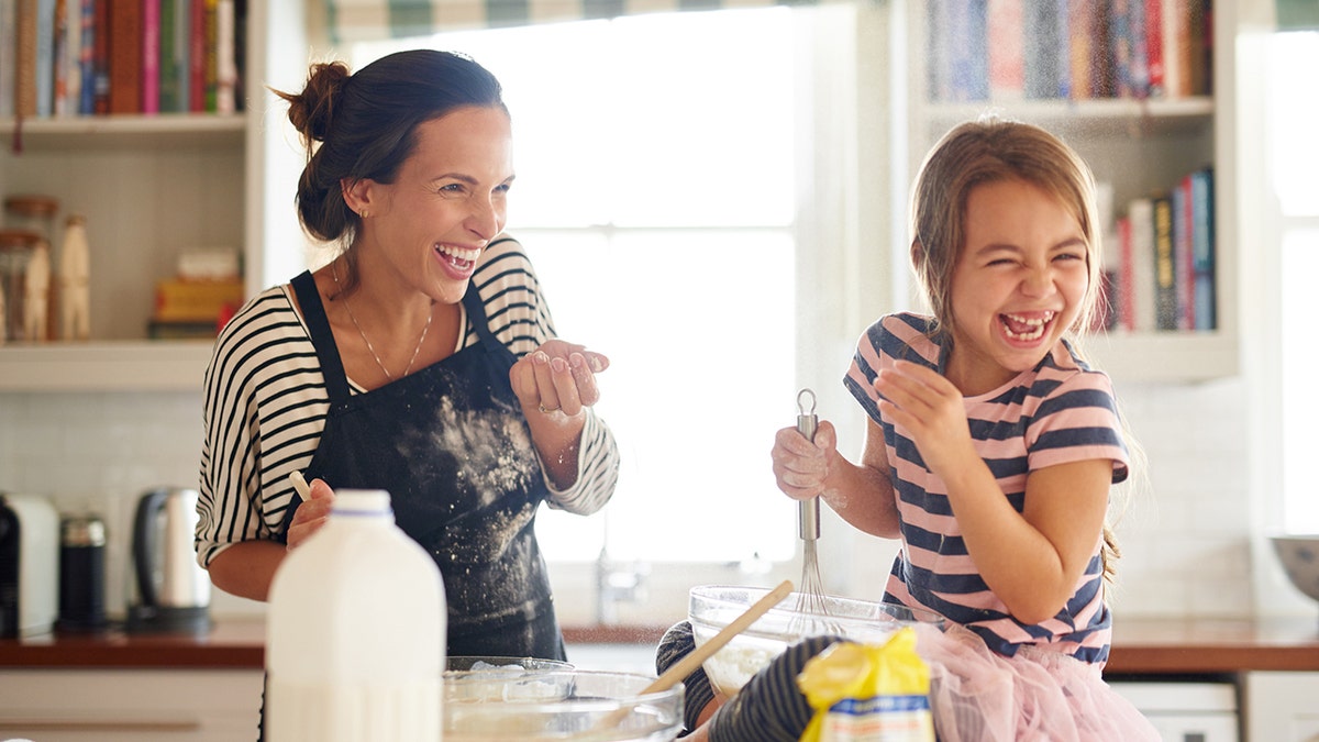 Niño y mamá cocinando en la cocina