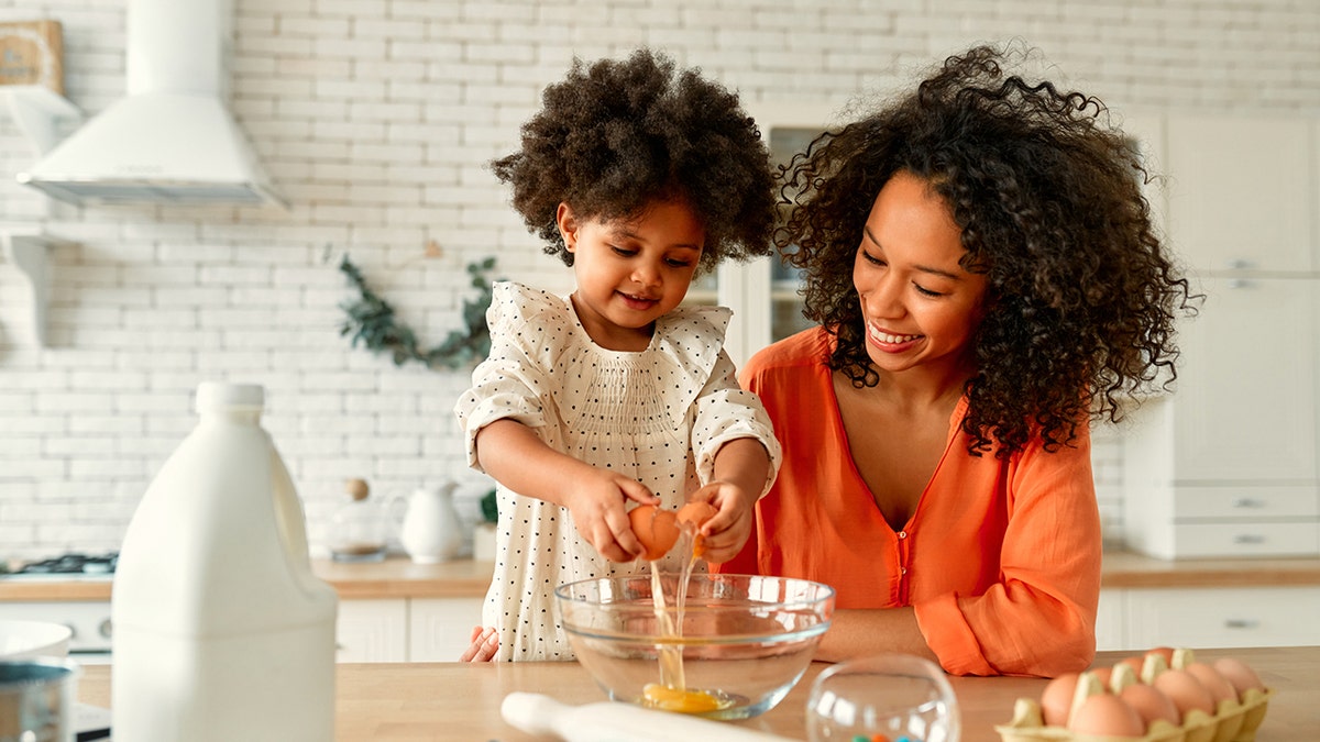 Niño y mamá cocinando en la cocina