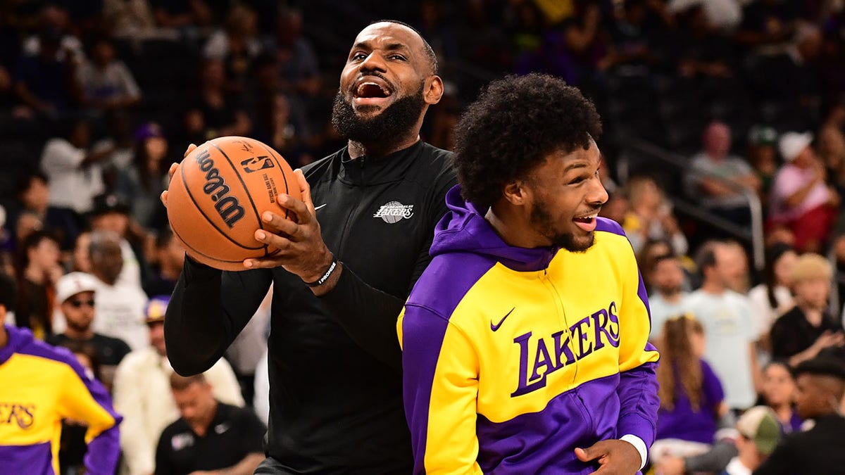 Lebron James and Bronny James laugh on the court