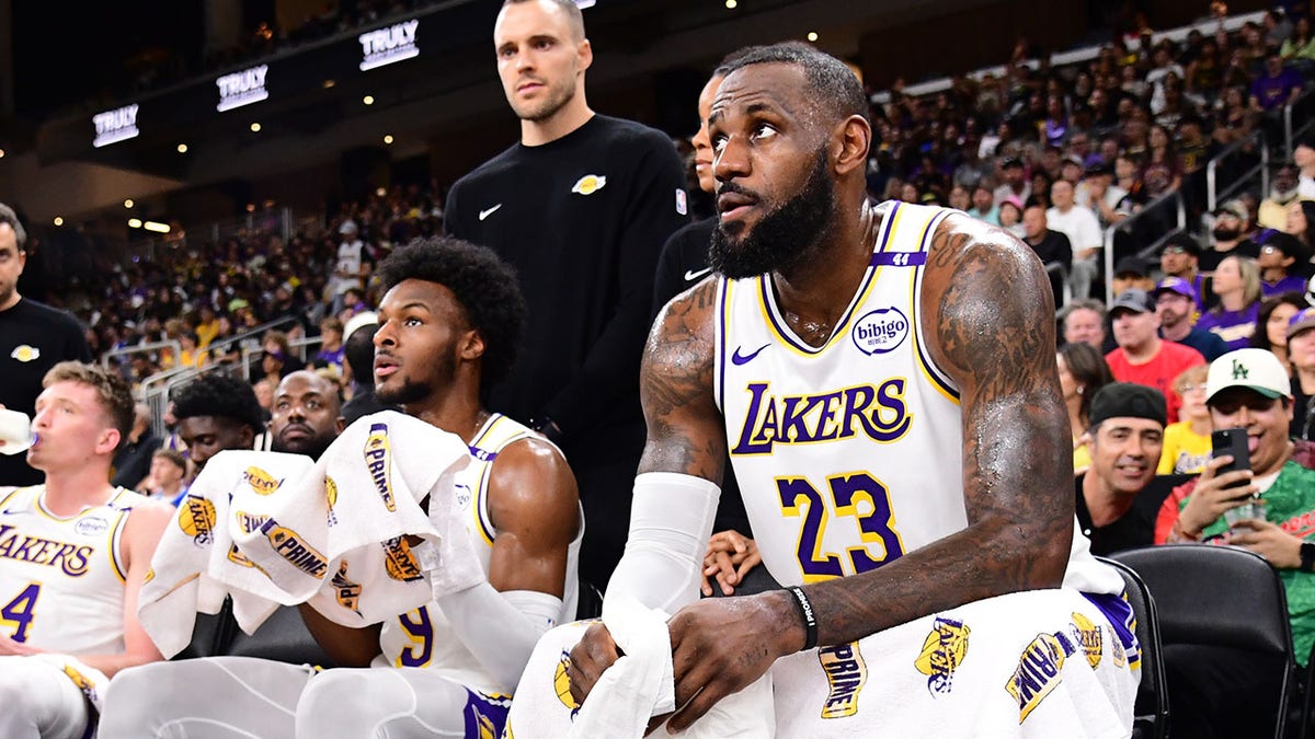 LeBron and Bronny James sit on the bench