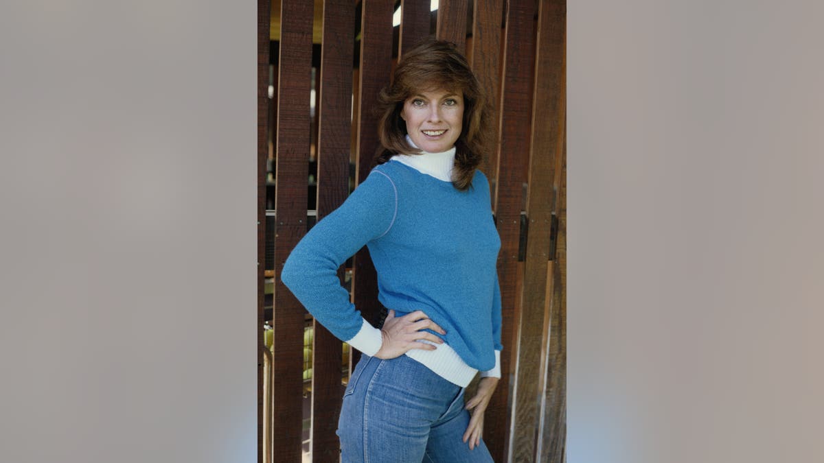 Linda Gray posing adjacent a obstruction successful nan 1980s