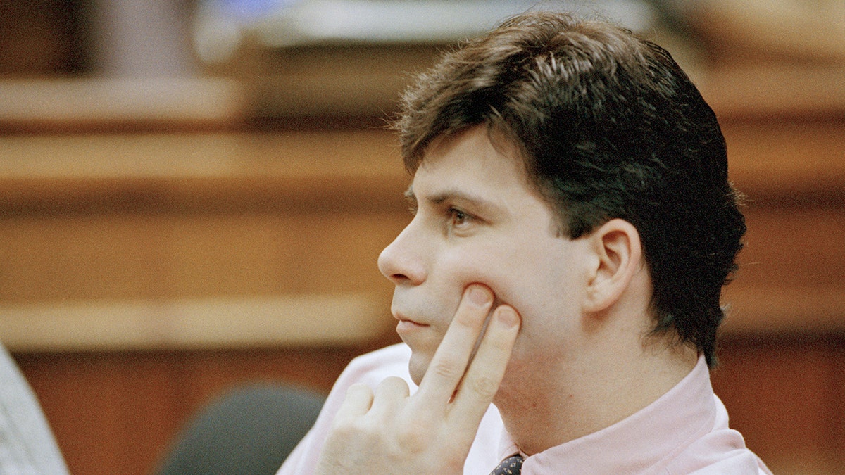 Lyle Menendez looks pensive successful tribunal holding 2 fingers up to his cheek