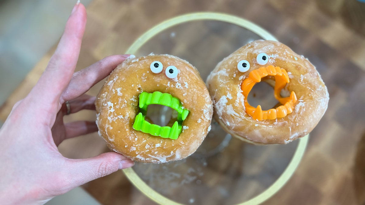 Mackenzie Biehl displays 2 of her "monster donuts" pinch vampire fangs.