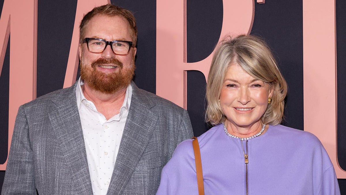 RJ Cutler smiles in a gray suit at the film premiere "Martha" with Martha Stewart in a lavender jacket