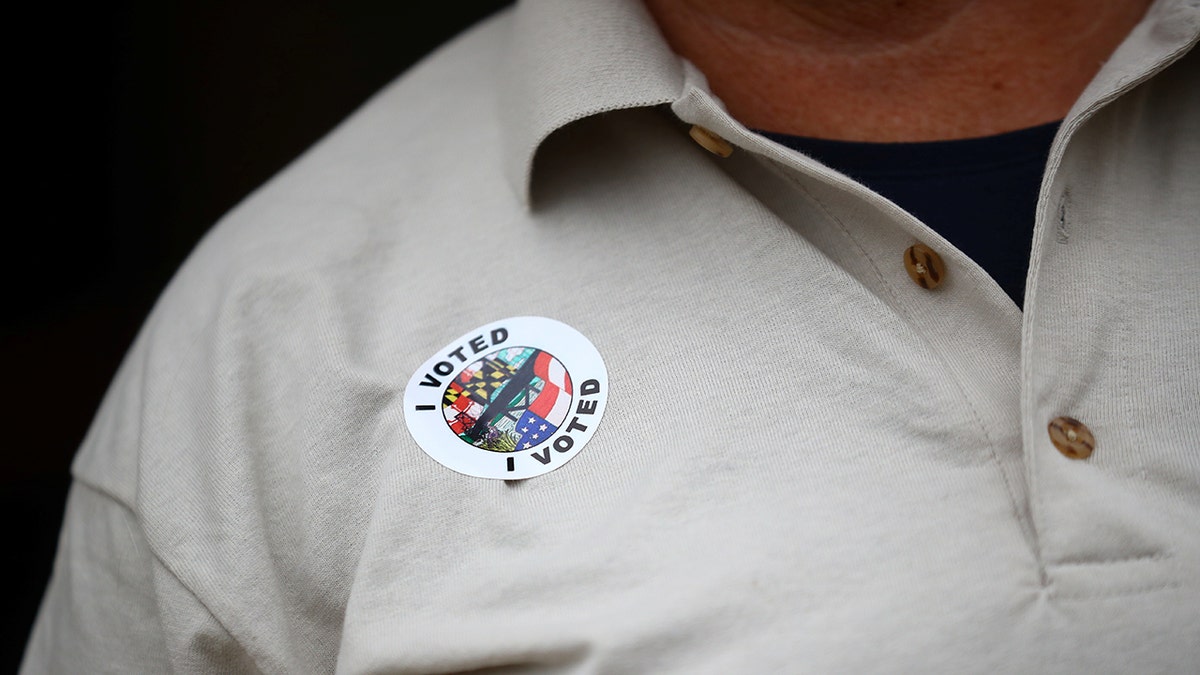 man with I Voted sticker connected  