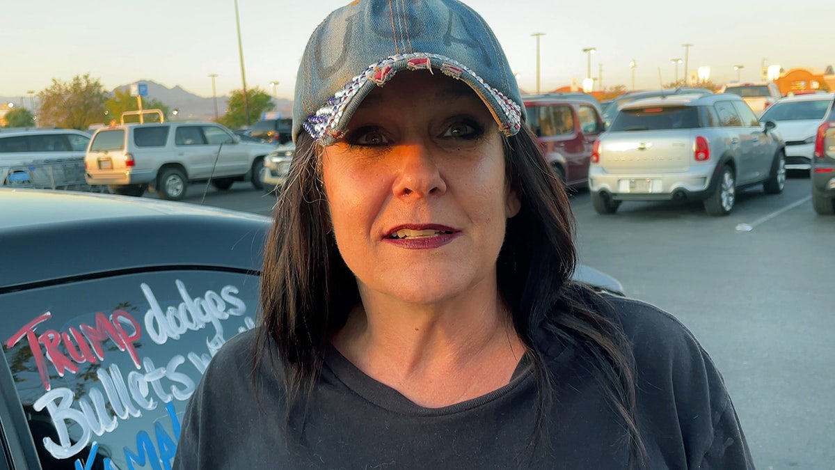 Woman with a hat that says: "USA" standing in the parking lot