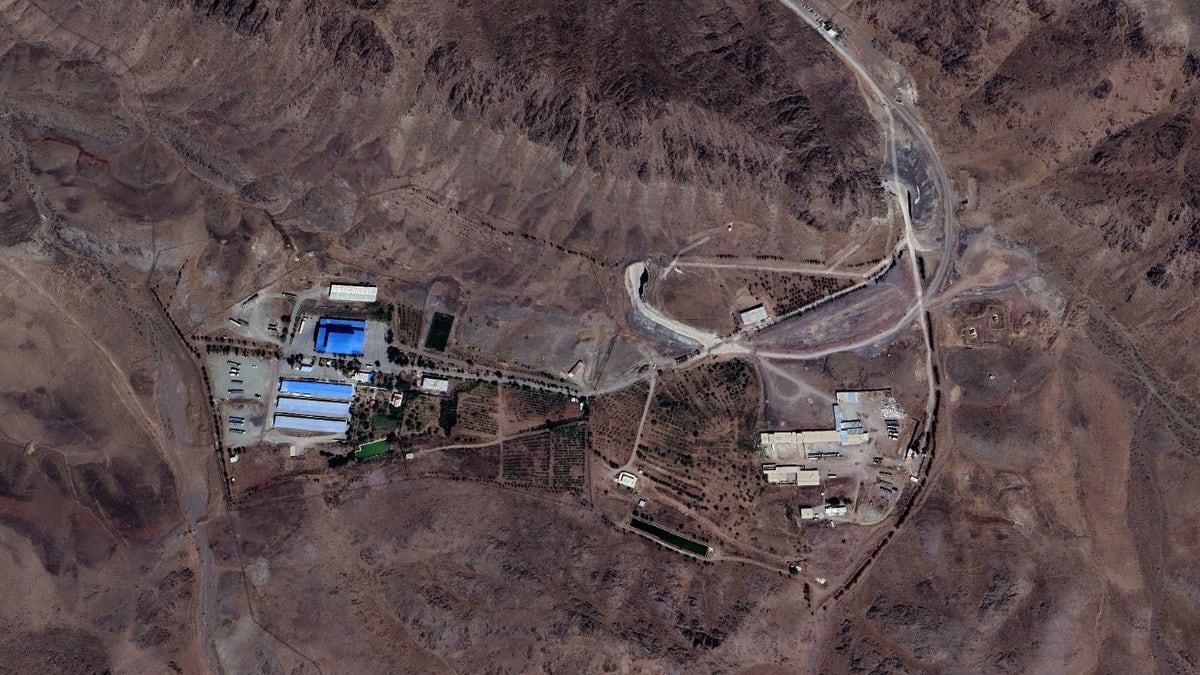 Satellite images show the Shahid Soltani Garrison outside Eshtehard City, Iran, containing large storage warehouses (left), a series of small buildings (right), and an underground tunnel with two openings (center).