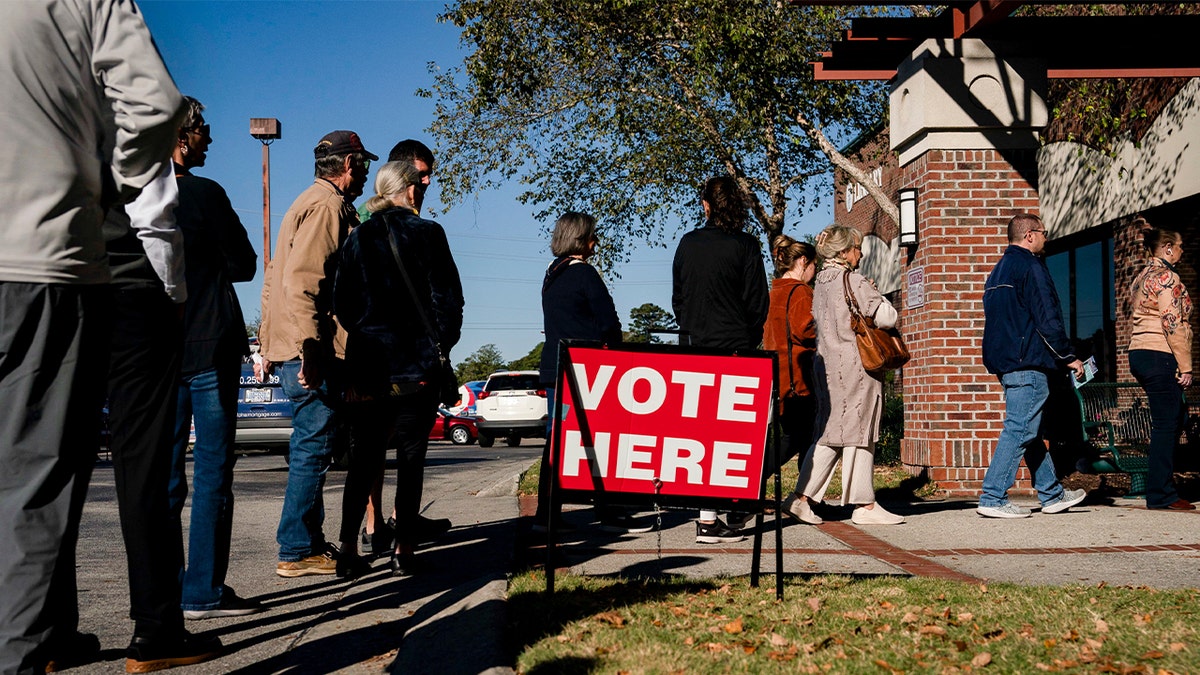 Voters wait in line to cast their ballots during the first day of early voting at a polling station in Wilmington, North Carolina, on Oct. 17.