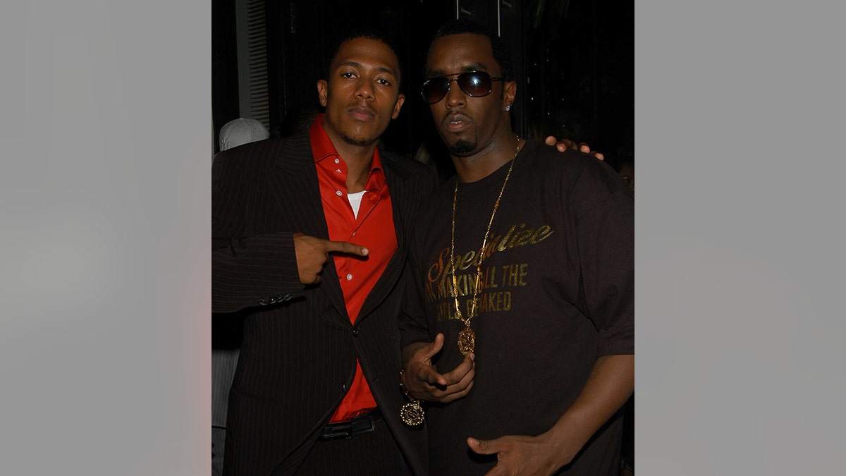 Nick Cannon wears reddish  garment  and suit   with Sean Diddy Combs.