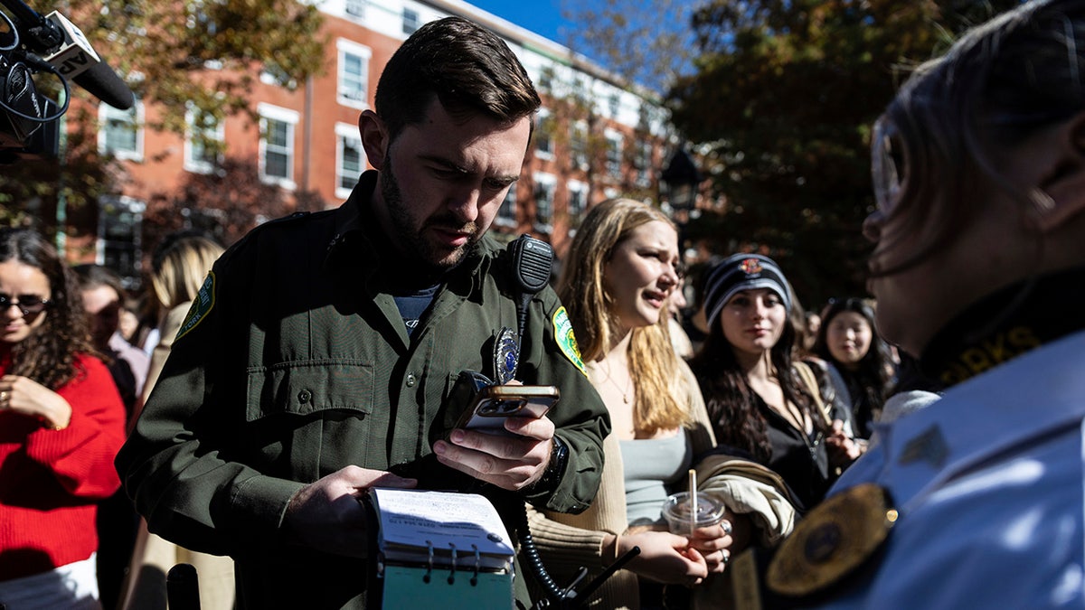 An serviceman  from the Parks Enforcement Patrol writes a summons  to the organizer of the Timothee Chalamet lookalike contention   successful  Washington Square Park