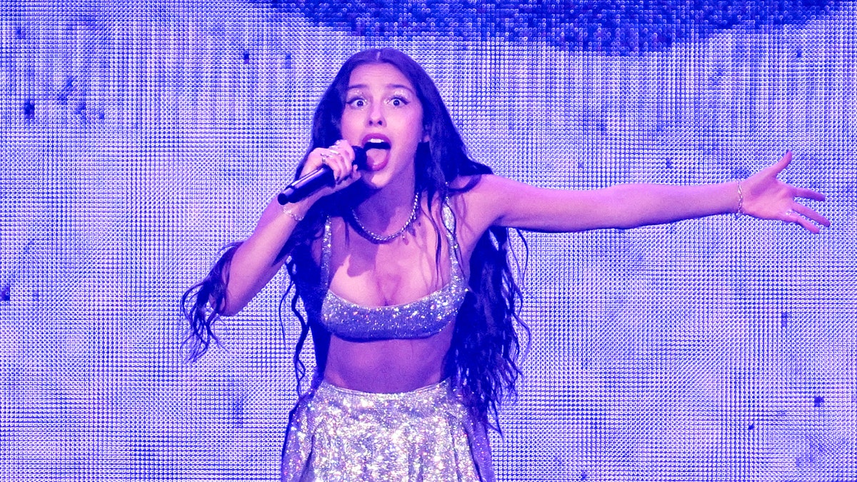 Olivia Rodrigo canta com roupa prateada brilhante