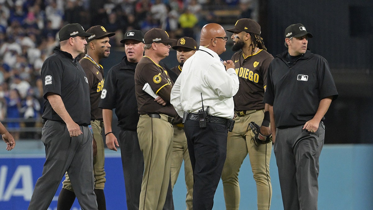 Padres, referees and security guards discuss on the field