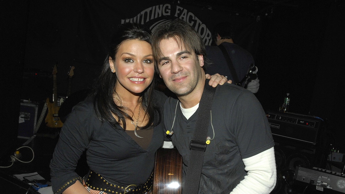 Rachael Ray poses with husband at a music show.