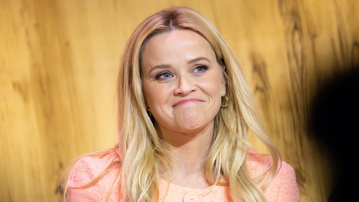 Reese Witherspoon wears an orange dress at an event in Los Angeles.