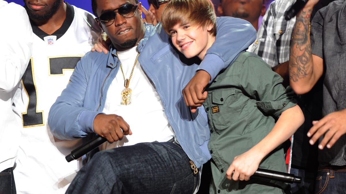 diddy with his arm around young justin biebers shoulder