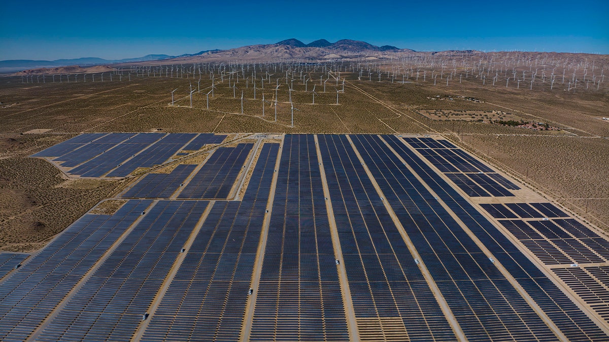 Wind and solar panels merge in a desert alternative energy site in Mojave, California.