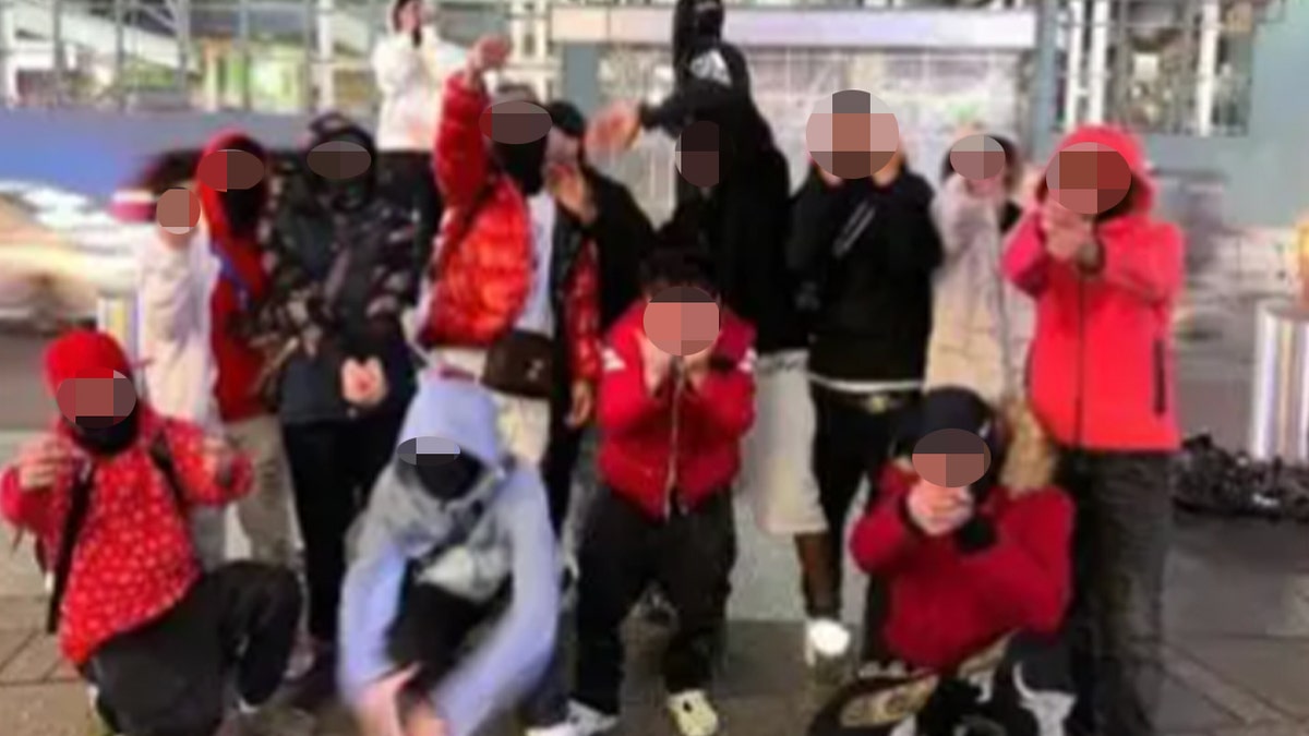 Suspect Tren de Aragua members wearing masks and hoods point fingers at the camera