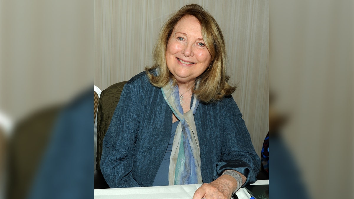 Actress Teri Garr wears blue suit with matching scarf.