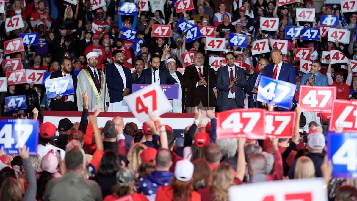 Republican presidential candidate and former President Donald Trump stands next to local Muslim leaders during a campaign rally at the Suburban Collection Showplace on Saturday, October 26, 2024, in Novi, Michigan. 