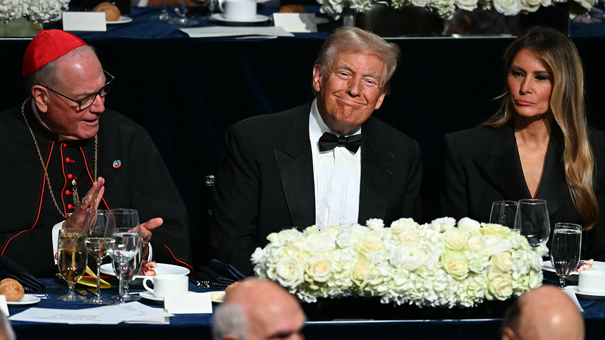  Mantan Presiden AS dan calon presiden dari Partai Republik Donald Trump bersama istrinya Melania Trump dan Uskup Agung New York Timothy M. Dolan (kiri) menghadiri Makan Malam Tahunan Alfred E. Smith Memorial Foundation ke-79 di Hilton Midtown di New York, 17 Oktober 2024. (Foto oleh Timothy A. CLARY / AFP) (Foto oleh TIMOTHY A. CLARY/AFP via Getty Images)