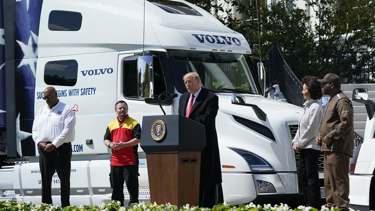 Former President Trump on the podium in front of a truck