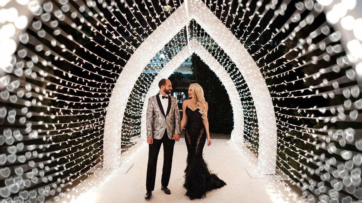 Christine Quinn and husband at wedding walking through tunnel of twinkling lights