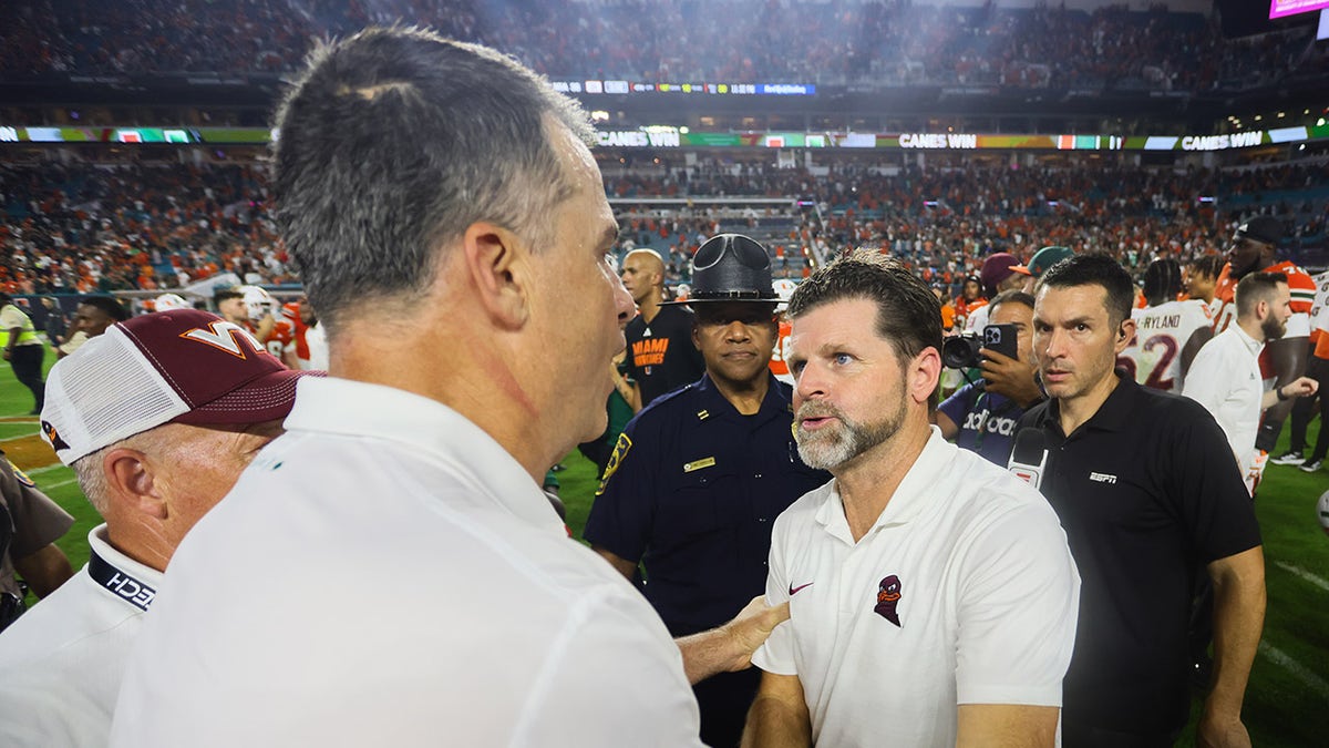 Brent Pry shakes hands with manager  Mario Cristobal