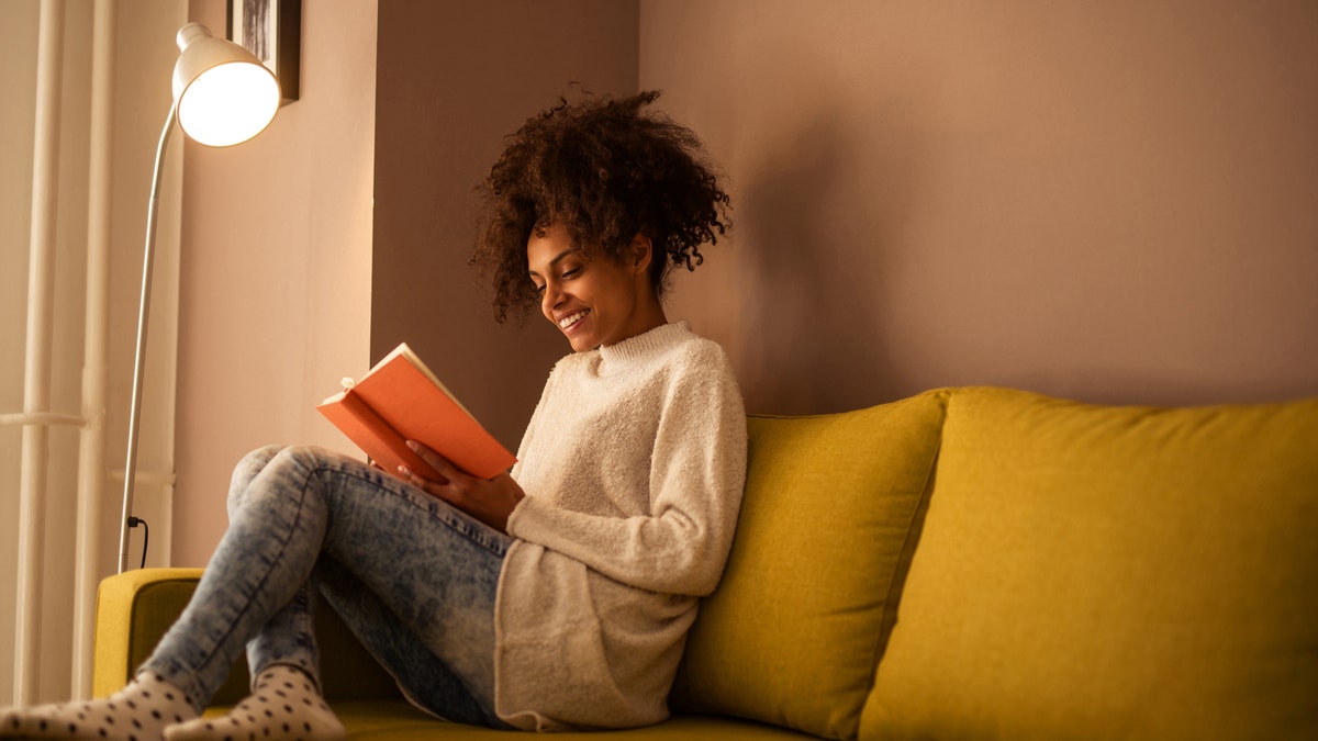 Mulher lendo um livro em casa