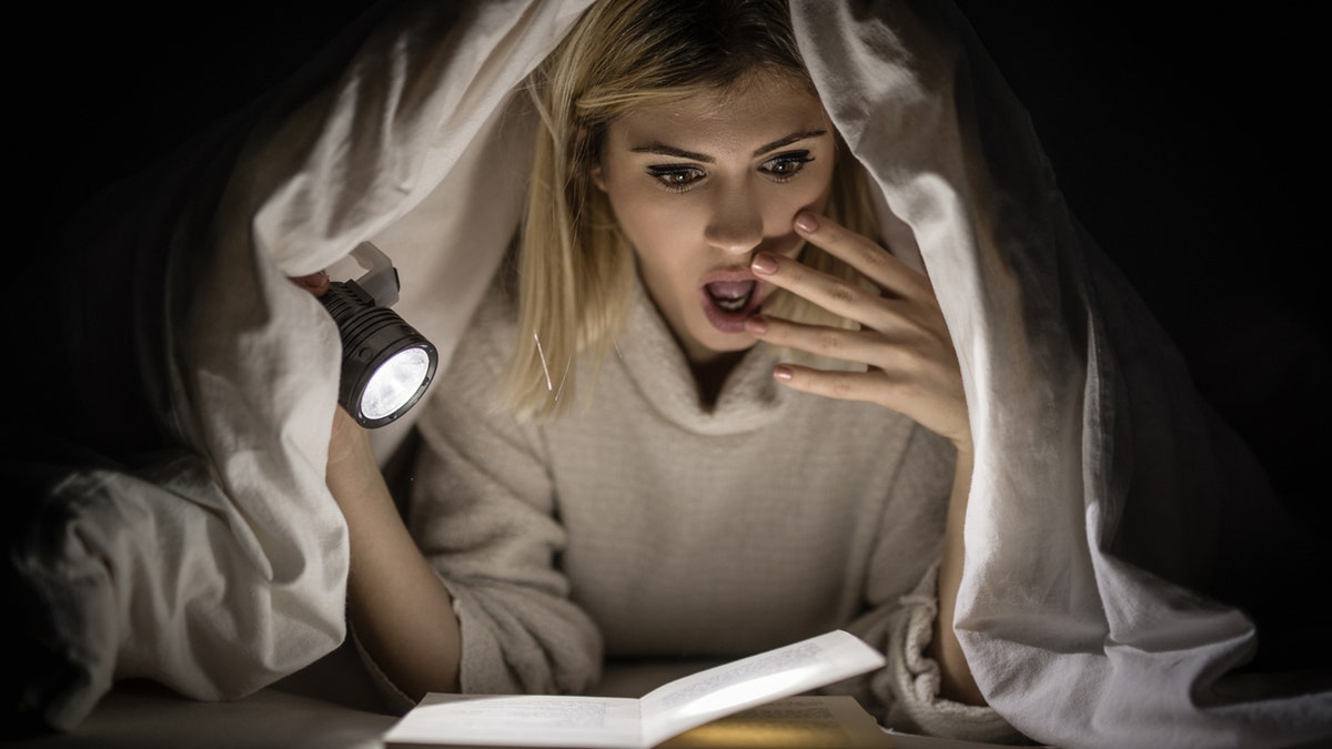 Una mujer leyendo un libro de miedo