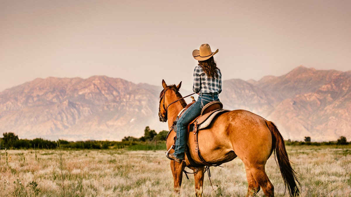 Una mujer montando a caballo