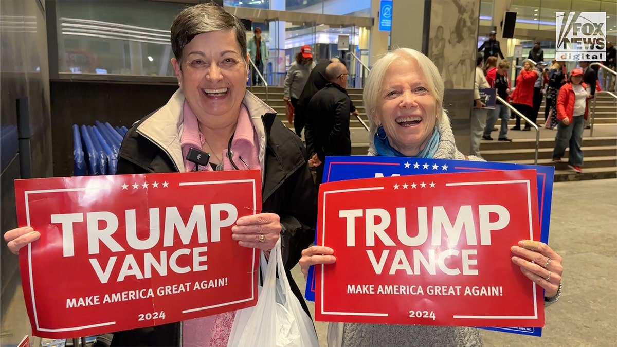 Two pistillate  supporters with Trump signs extracurricular  the Trump Madison Square Garden rally