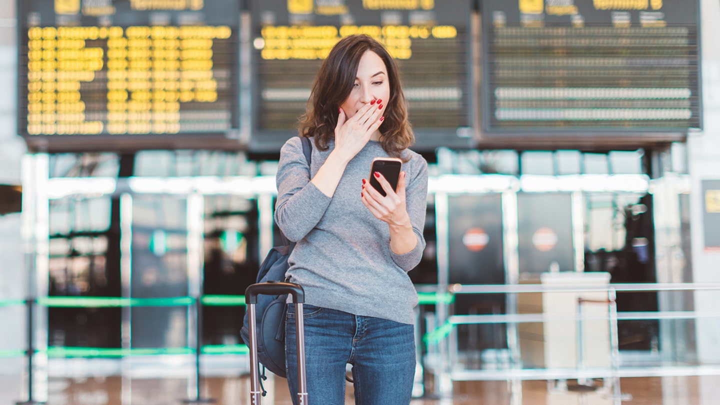 woman looks at phone shocked