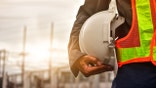 Construction worker holding hard hat under arm
