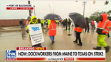 Striking longshoremen walk in the rain at the Port of Baltimore as both sides jockey for position in negotiations.