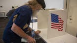 An polling volunteer sanitizes a voting booth at a polling location for the 2020 Presidential election in Ankeny, Iowa, U.S., on Tuesday, Nov. 3, 2020. American voters, at least those who've not yet cast ballots, go to the polls Tuesday to choose between President Donald Trump and Democratic nominee Joe Biden and cast votes in U.S. House and Senate races and state and local elections. Photographer: Rachel Mummey/Bloomberg via Getty Images